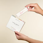 Laura Ashley perfume packaging with a hand holding it against a beige background